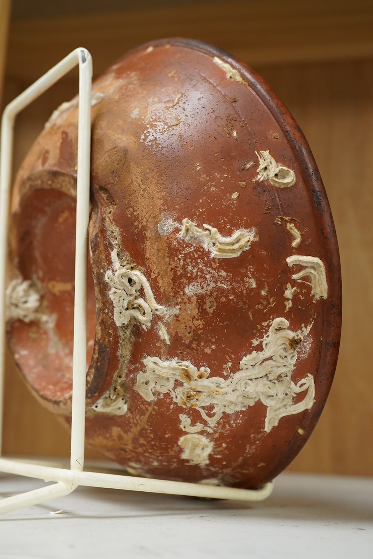 A Roman Samian ware bowl with provenance, allegedly from the Pan Rock shipwreck, together with an Iron Age Quern stone, largest 19cm in diameter